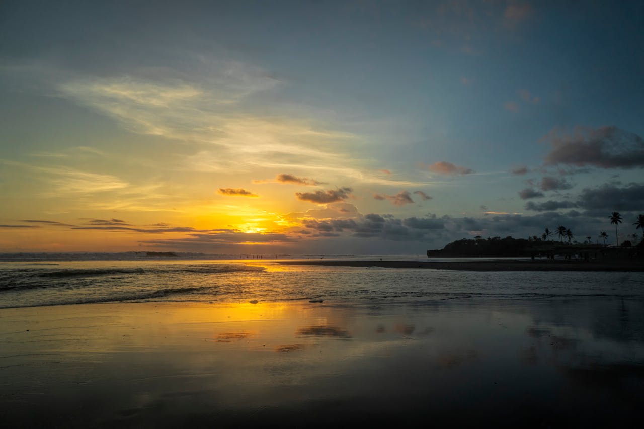 Beautiful sunset reflecting over a tranquil beach in Bali, Indonesia.